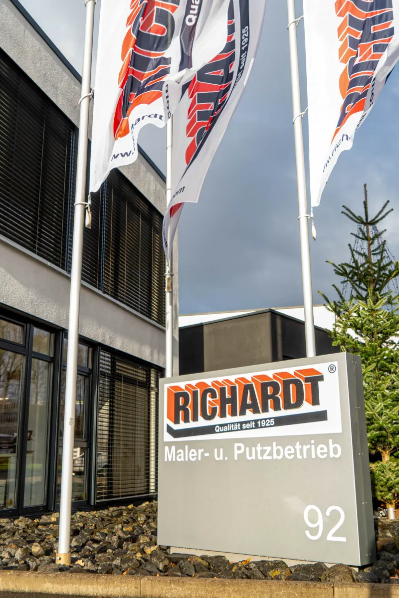 Betriebsgebäude der Richardt GmbH in Bebra mit Firmenschild „Qualität seit 1925“ und Fahnen.