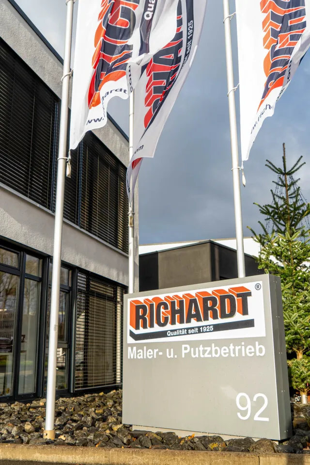 Betriebsgebäude der Richardt GmbH in Bebra mit Firmenschild „Qualität seit 1925“ und Fahnen.