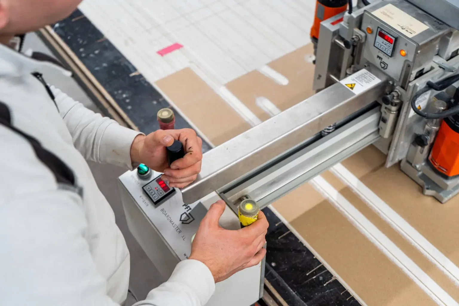 Nahaufnahme: Hände bedienen die CNC-Fräse im Betrieb der Richardt GmbH.