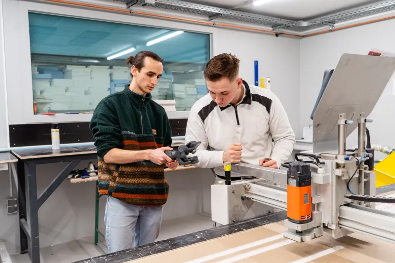 Drehtermin in der Fertigungshalle der Richardt GmbH: Ein Mitarbeiter zeigt einen Arbeitsschritt an der Maschine, daneben wird mit der Kamera gefilmt.