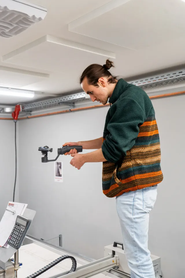 Mitarbeiter von GRZ Digital filmt mit einer Kamera auf einem Gimbal in der Fertigungshalle der Richardt GmbH.