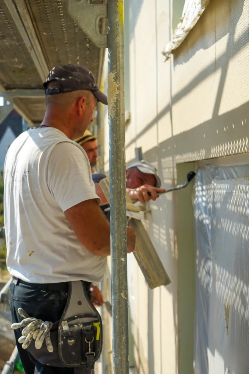 Handwerker der Richardt GmbH beim Verputzen einer Hausfassade.