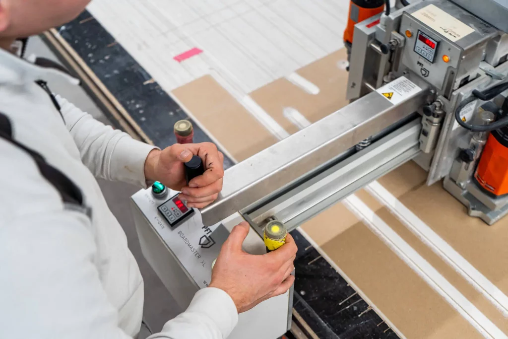 Referenz richardt.com, Handwerker bedient die CNC-Fräsmaschine zur präzisen Bearbeitung von Platten.