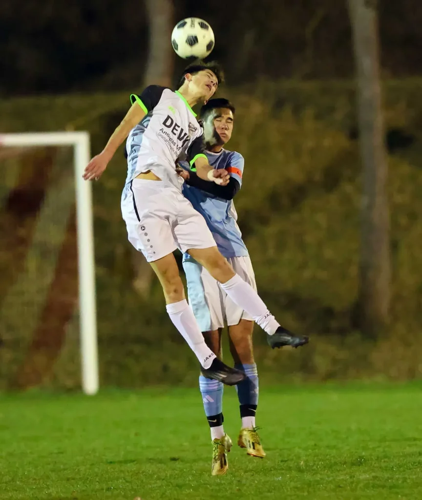 Zweikampf um den Ball: Zwei Fußballer links vom JFV Ulfetal steigen im Flutlicht zum Kopfball hoch.